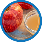 Fresh apple and apple cider vinegar in a glass bowl, ideal for ACV gummies with the mother for optimal health benefits.